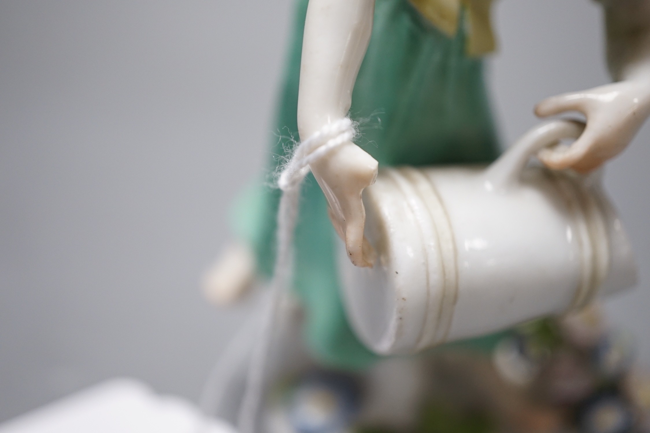 An 18th century Meissen figure of a girl pouring water from a jug on flowers at her feet, c.1755, 12cm tall